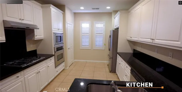 a kitchen with granite countertop a stove and a refrigerator
