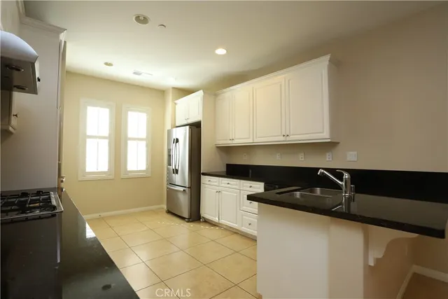 a kitchen with a refrigerator and a stove top oven