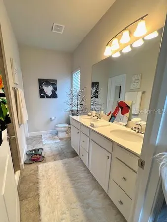 a spacious bathroom with a double vanity sink mirror vanity and toilet