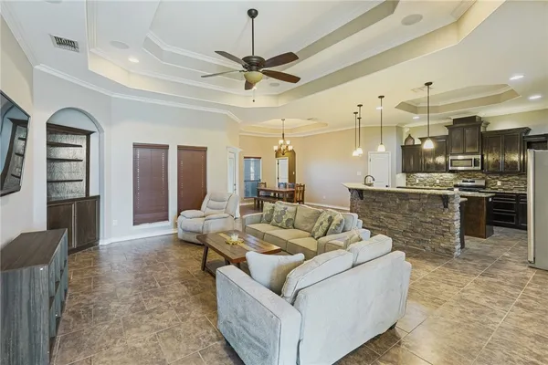 a living room with furniture and a view of kitchen