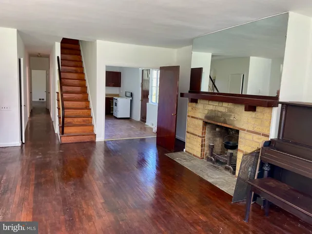 a view of a livingroom with wooden floor and stairs