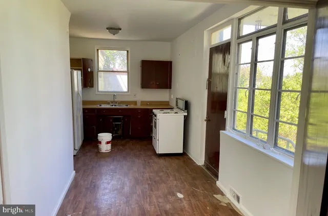 a view of a kitchen with a sink wooden floor and windows