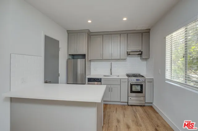 a kitchen with stainless steel appliances granite countertop a stove a sink and a refrigerator