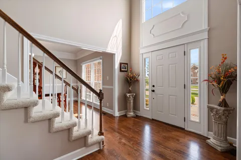 a open kitchen with stainless steel appliances granite countertop a stove top oven a refrigerator a kitchen island a dining table and chairs