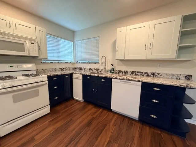 a kitchen with wooden floors appliances and cabinets