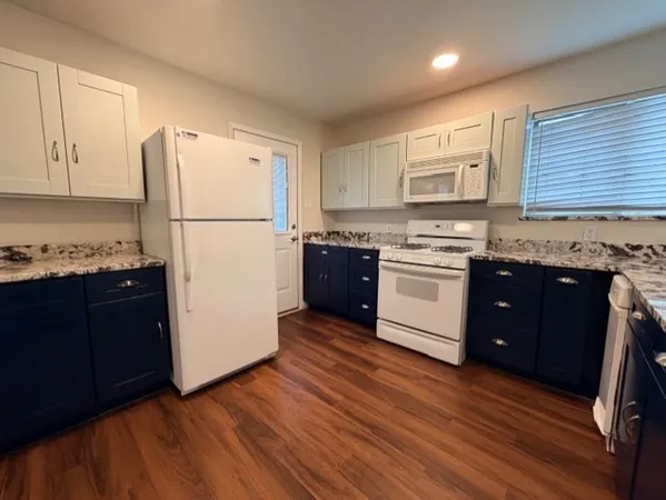 a kitchen with stainless steel appliances granite countertop a refrigerator a stove a sink and a microwave