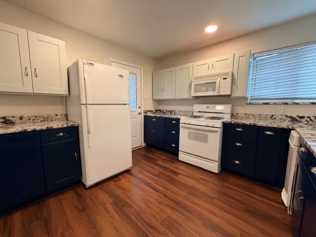 a kitchen with stainless steel appliances granite countertop a refrigerator a stove a sink and a microwave