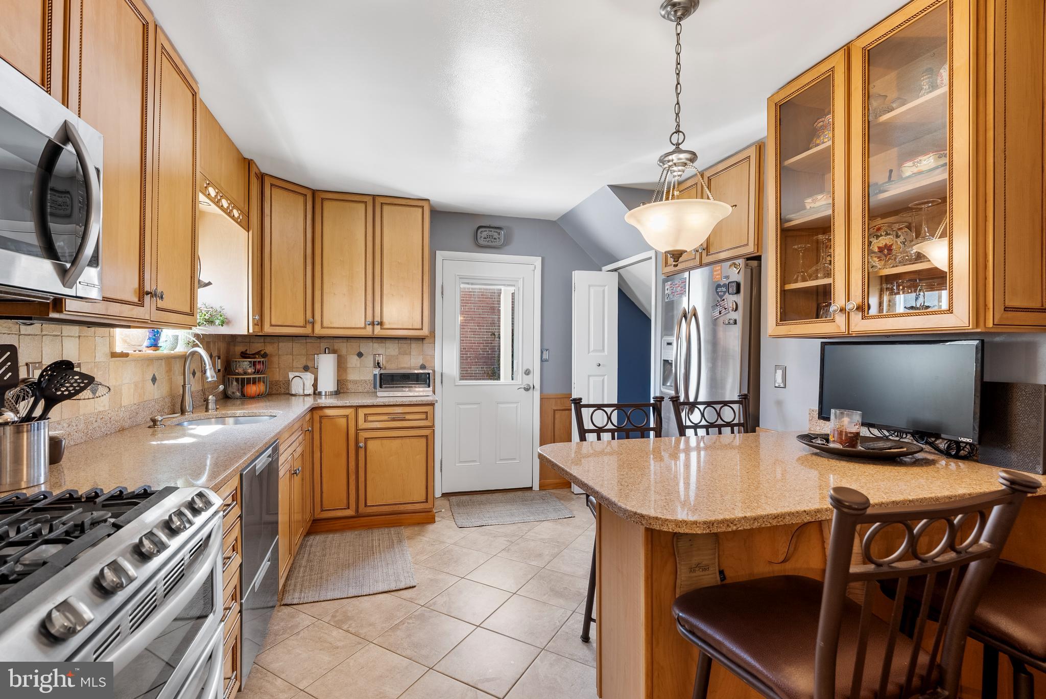 907 Arran Road Baltimore, MD 21239 - Photo 15 of 41 a kitchen with sink a stove and chairs