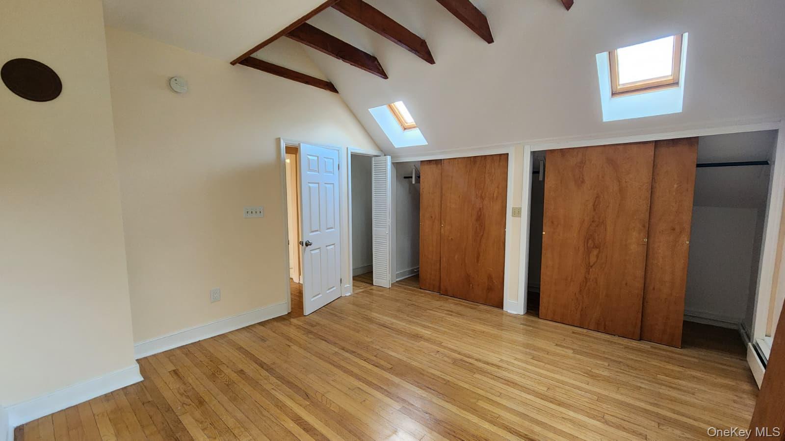 92 Roe Avenue, Unit 3 Highland Falls, NY 10928 - Photo 16 of 17 Hardwood flooring throughout this room featuring exposed wood beams, skylights, and double sliding panel closets