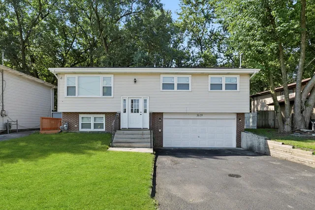 a view of a house with a yard and a garage