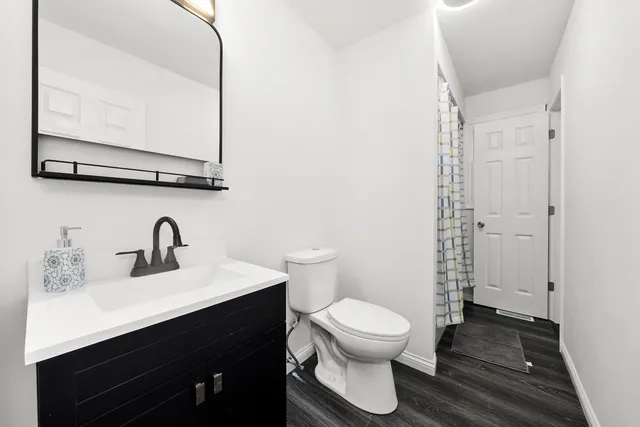 a bathroom with a sink a toilet and a mirror