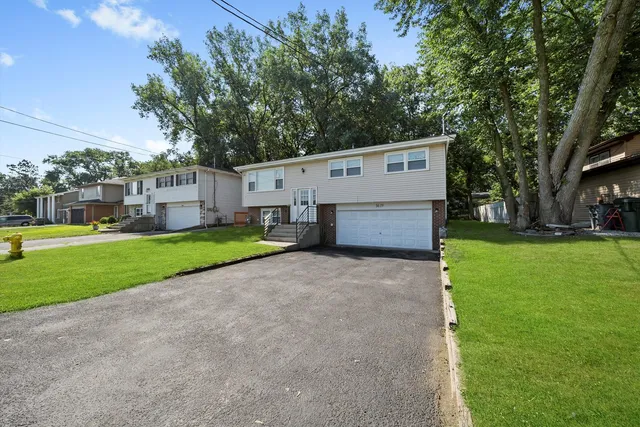 a view of a house with backyard and a tree