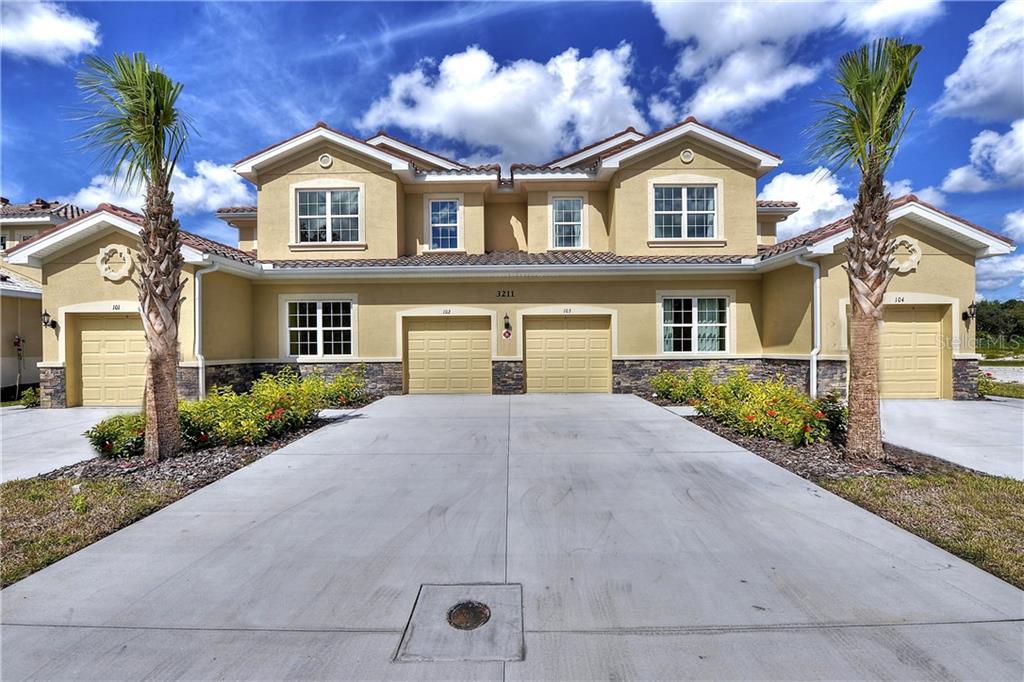 8219 Enclave Way, Unit 104 Sarasota, FL 34243 - Photo 1 of 1 a front view of a house with garden