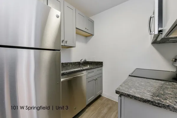 a kitchen with stainless steel appliances granite countertop cabinets and a refrigerator
