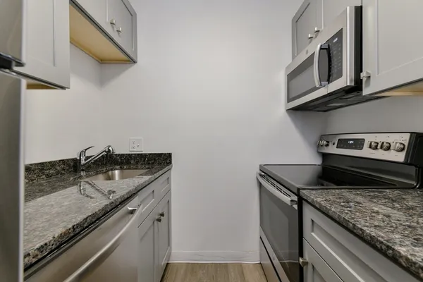 a kitchen with stainless steel appliances granite countertop a sink stove and cabinets