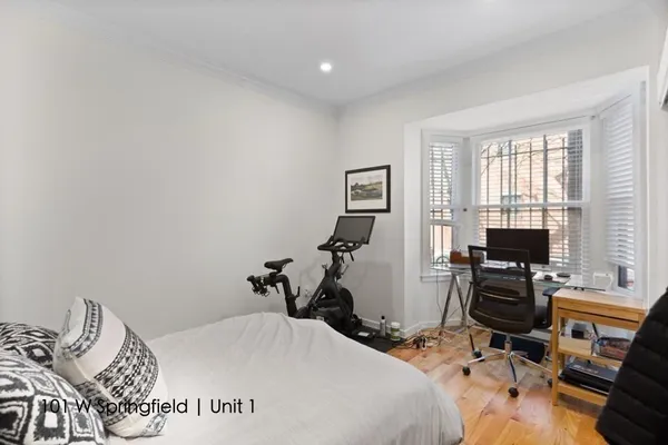 a bedroom with a bed and wooden floor