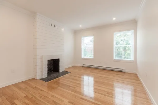 a view of an empty room with window and fire place