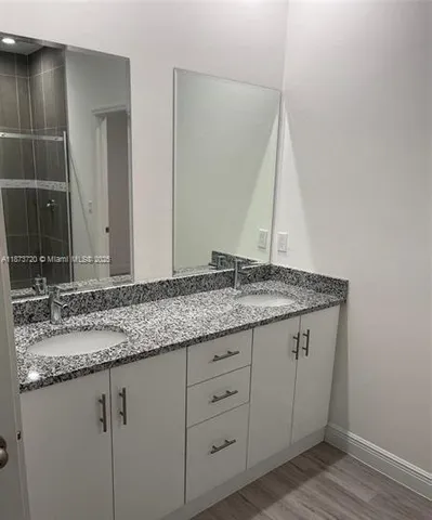 a bathroom with a granite countertop sink and a mirror