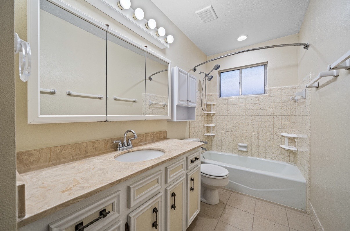 4822 Lost Oak Drive Spring, TX 77388 - Photo 12 of 14 a bathroom with a granite countertop sink a toilet a mirror and shower