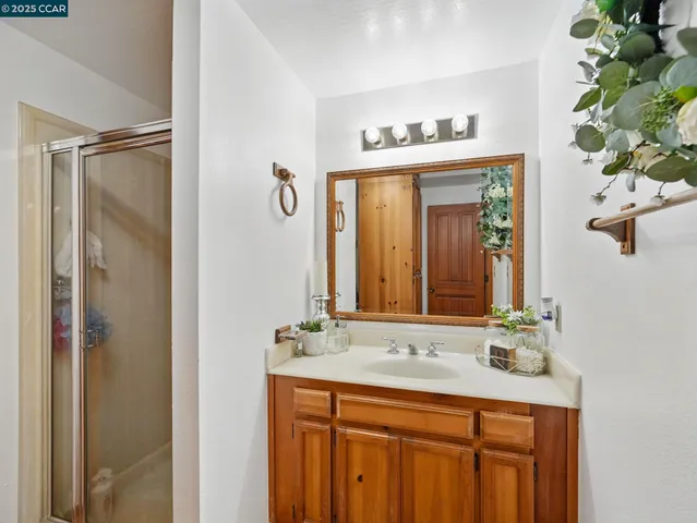 a bathroom with a granite countertop sink a mirror and a shower