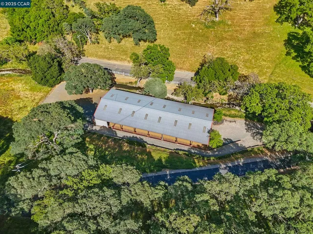 a view of a grey house with a yard