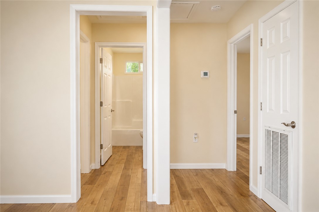 605 Hampton Street Iva, SC 29655 - Photo 9 of 16 Hallway connecting multiple rooms, featuring resilient hardwood flooring throughout the interior.