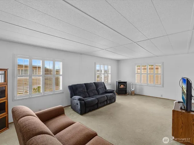a living room with furniture a flat screen tv and a window