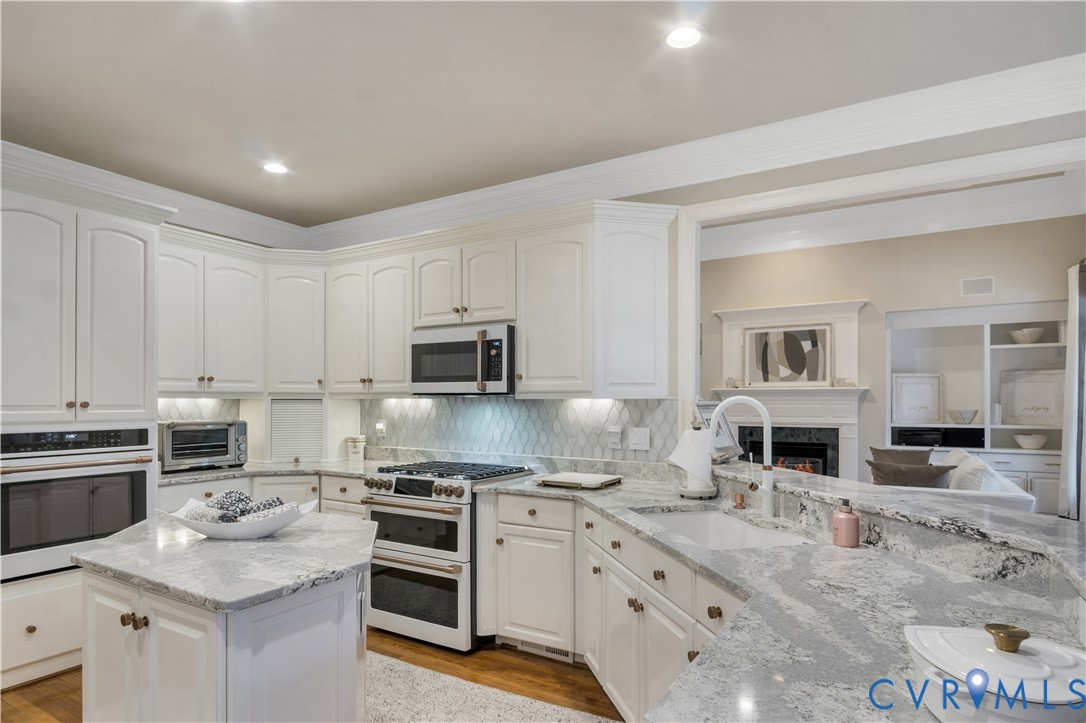 2509 Nathaniell Powell Road Williamsburg, VA 23185 - Photo 13 of 53 a kitchen with kitchen island granite countertop a sink stove oven and granite counter tops