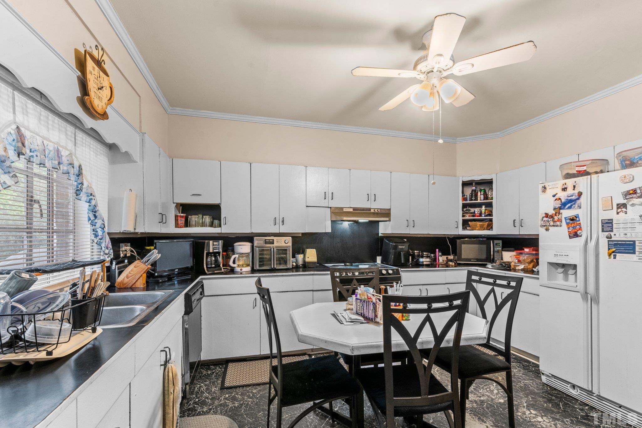125 King William Road Raleigh, NC 27610 - Photo 29 of 33 a kitchen with stainless steel appliances a table chairs and a refrigerator