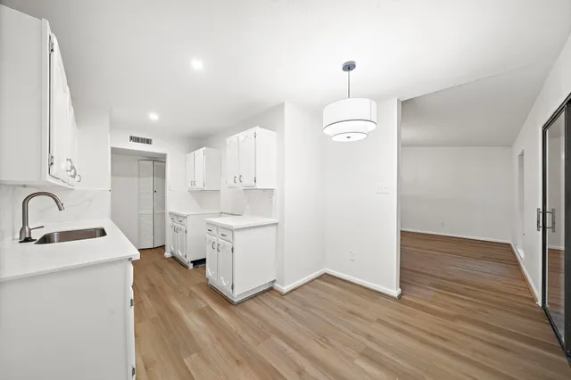 a kitchen with a refrigerator sink and cabinets