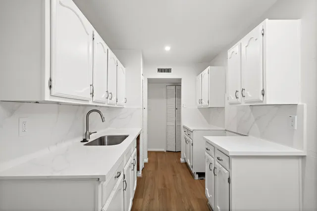 a kitchen with a sink a stove and cabinets