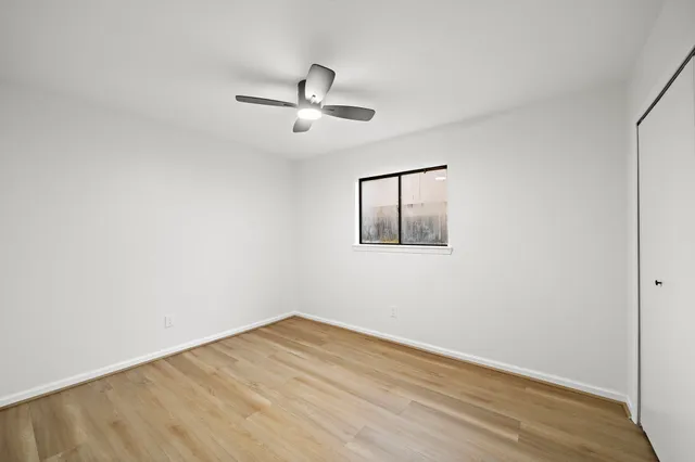 a view of empty room with wooden floor