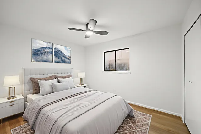 a bedroom with a large bed and a painting on the wall