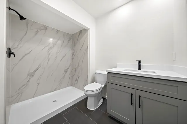 a bathroom with a sink a toilet and shower