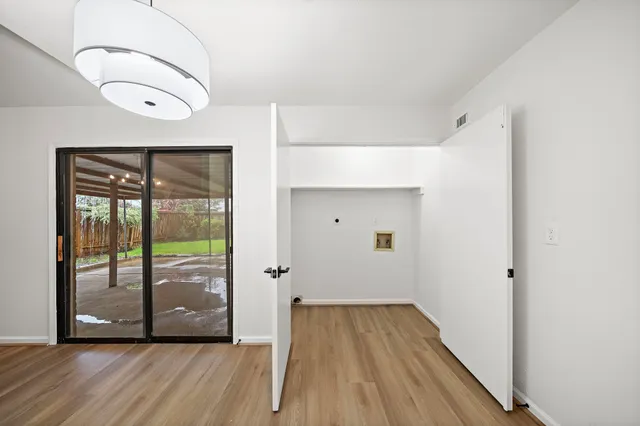 a view of a hallway with wooden floor and glass door