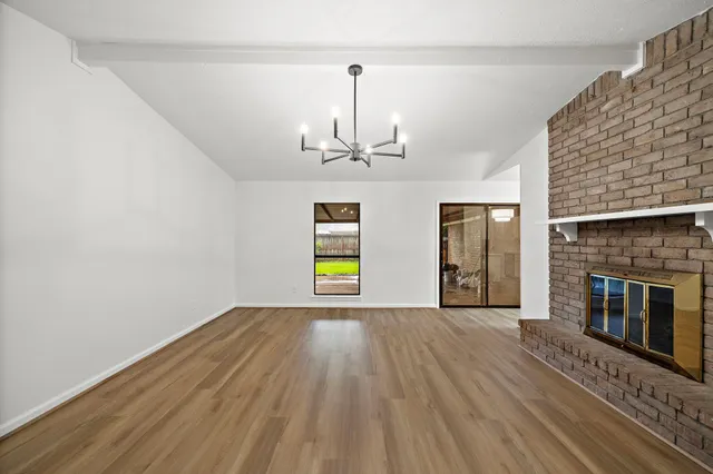 a view of empty room with wooden floor and fireplace