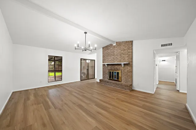 wooden floor fireplace and windows in an empty room