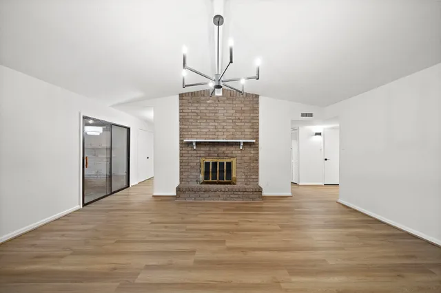 a view of an empty room with a fireplace and a window