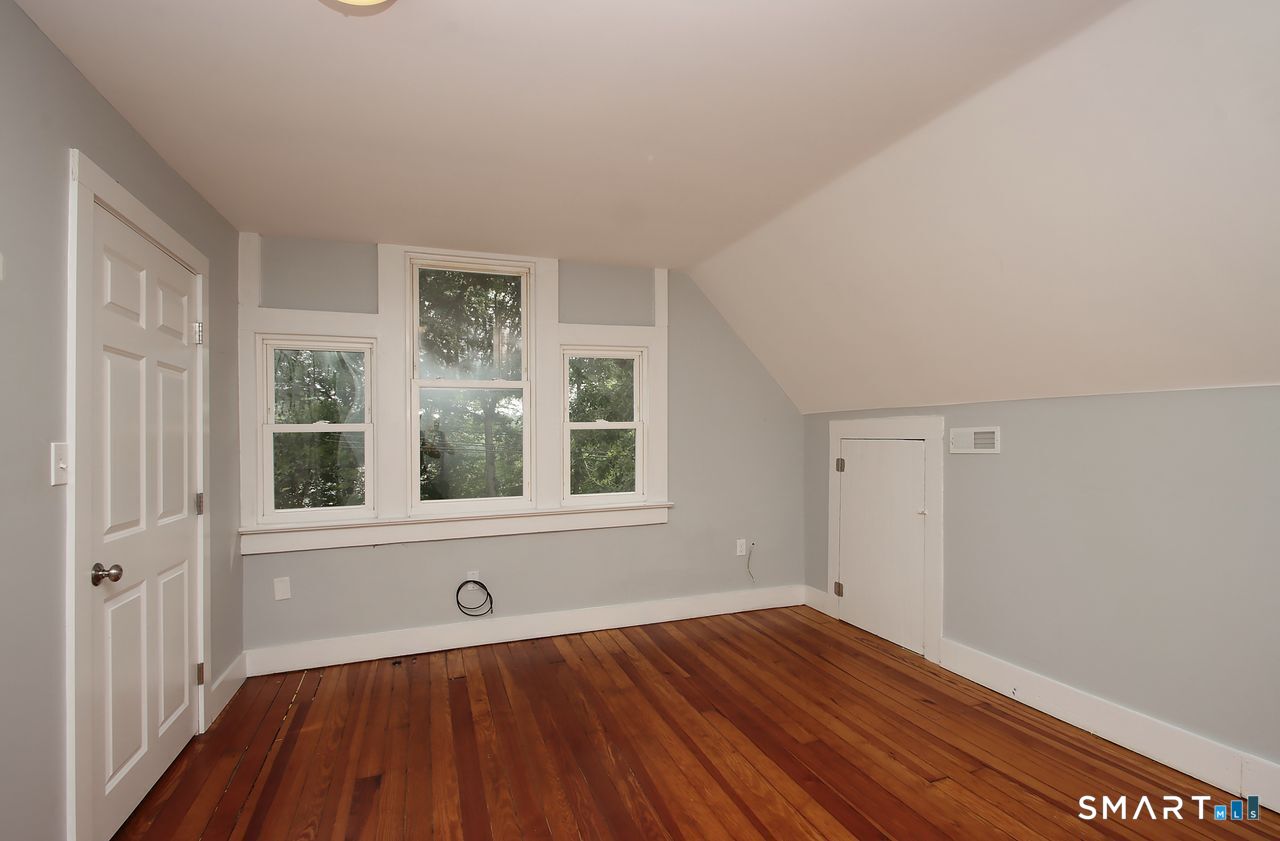 141 Duck Hole Road Madison, CT 06443 - Photo 19 of 22 a view of an empty room with wooden floor and a window