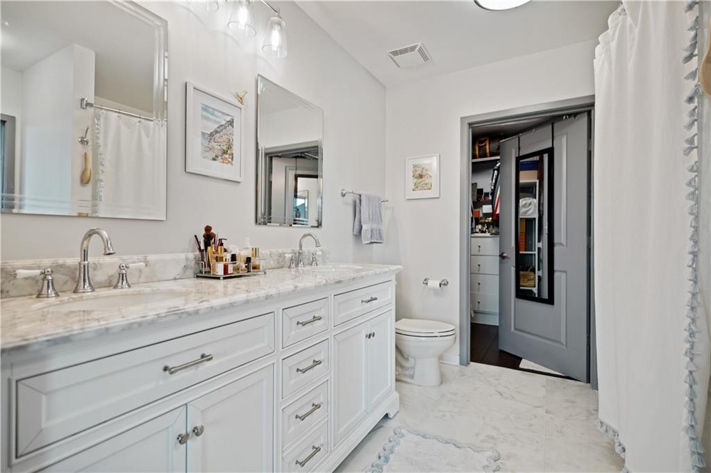 a spacious bathroom with a granite countertop sink and a mirror