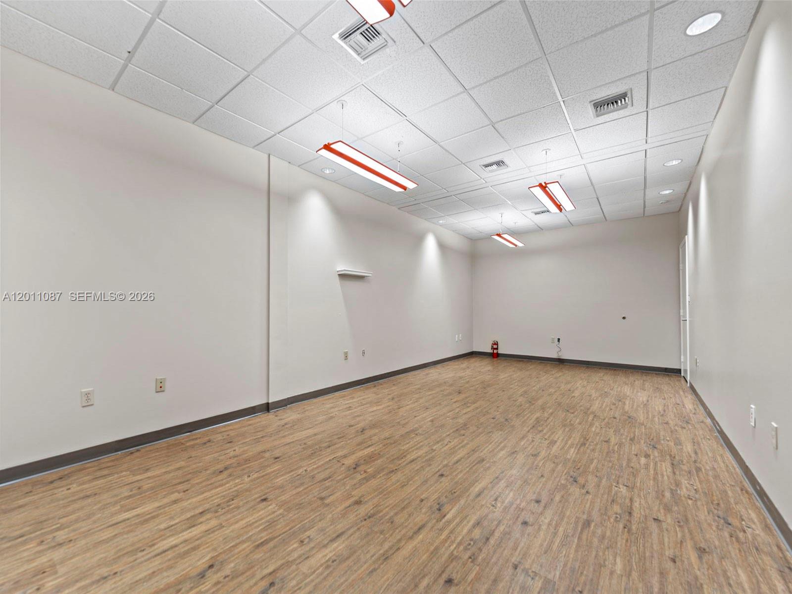 735 Shotgun Road Sunrise, FL 33326 - Photo 9 of 21 an empty room with wooden floor and windows