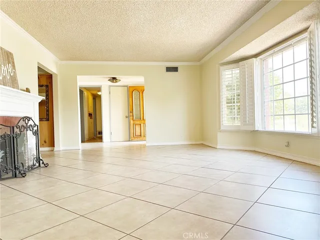 a view of empty room with wooden floor and window