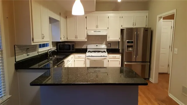 a kitchen with kitchen island a appliances a sink and a refrigerator