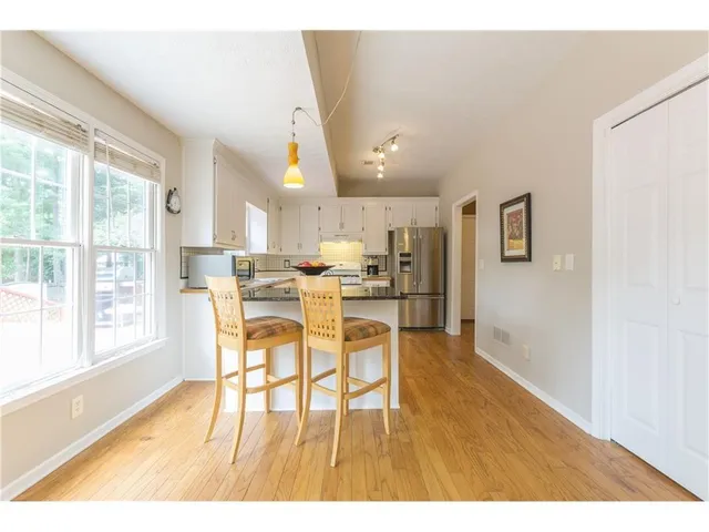a view of a roof deck with table and chairs under an umbrella with wooden floor