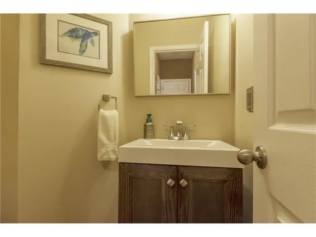 a living room with stainless steel appliances kitchen island granite countertop a refrigerator a stove a sink dishwasher with a dining table and chairs with wooden floor