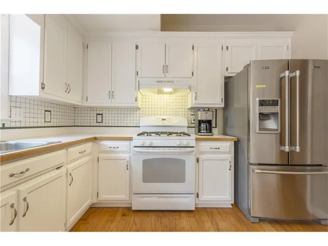a kitchen with a refrigerator cabinets and wooden floor