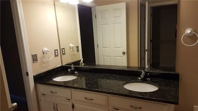 a bathroom with a double vanity sink and a mirror
