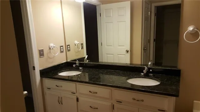 a bathroom with a double vanity sink and a mirror