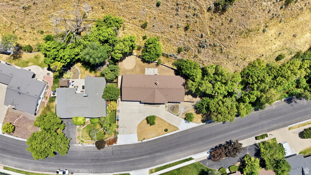 1410 Sumac Drive Logan, UT 84321 - Photo 2 of 28 Residential property featuring a spacious lot with mature trees, a paved driveway, and a shingle roof