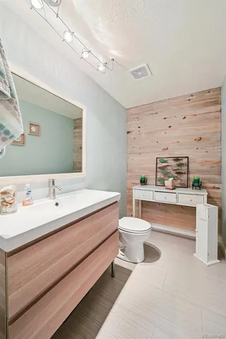 a bathroom with a bathtub sink vanity mirror and toilet